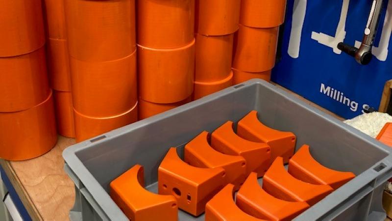 Orange acetal machined parts in a box